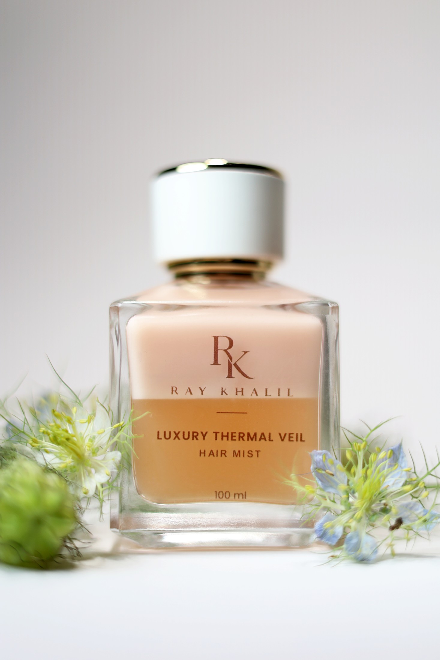Luxury Thermal Veil Hair Mist photographed with flowers